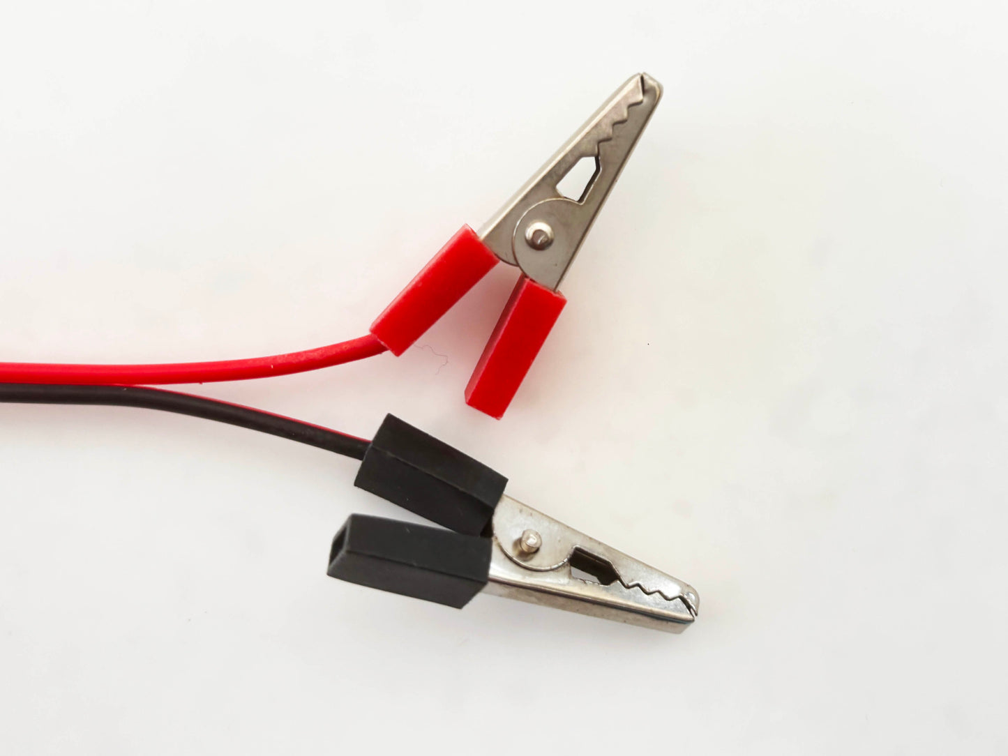 Custom alligator clip with red and black leads on a white background