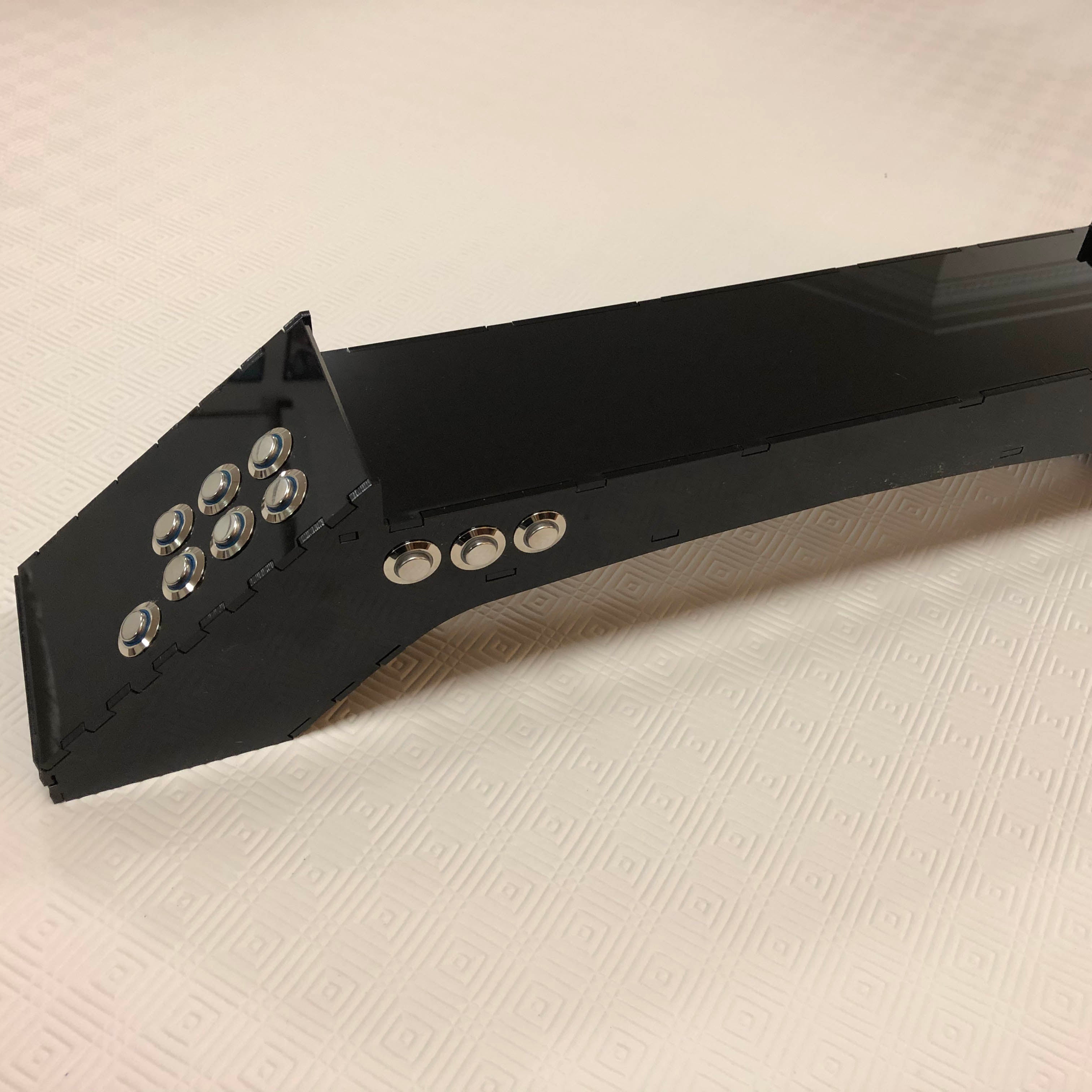 A long black bridge shape with 7 buttons on the end and three on the front. 