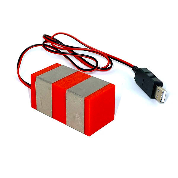 Usb plug cable behind a red plastic TapeBlock that has 2 parallel rows of silver tape around it.