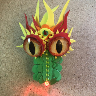 A GreenTapeBlock Dragon with scales, Large yellow and red eyes, Red Light up nose