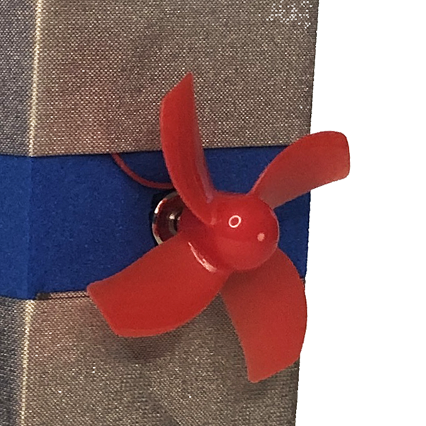A close up photo of a red fan and motor. The middle blue of the block and tape is showing