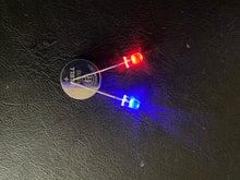 Load image into Gallery viewer, Red and Blue flashing LEDs with the legs on a 3V battery
