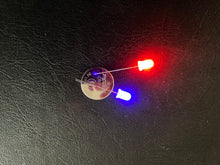 Load image into Gallery viewer, Red and Blue LEDs with legs of different lengths around a 3v Battery
