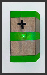 Foam block with two rows of conductive tape. Color of the light is changing Red,Yellow, Green, Blue, Purple showing. Plus sign on the top row of Tape to indicate direction