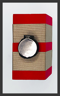 Foam block with two rows of conductive tape. A Battery holder is connecting the two rows of tape with a 3V button cell battery