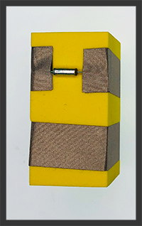 Foam block with two rows of conductive tape. One Row of tape is not continuous  as there is a silver tube tilt switch bridging the Tape