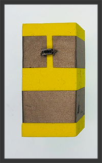 Foam block with two rows of conductive tape. One Row of tape is not continuous  as there is a button bridging the Tape