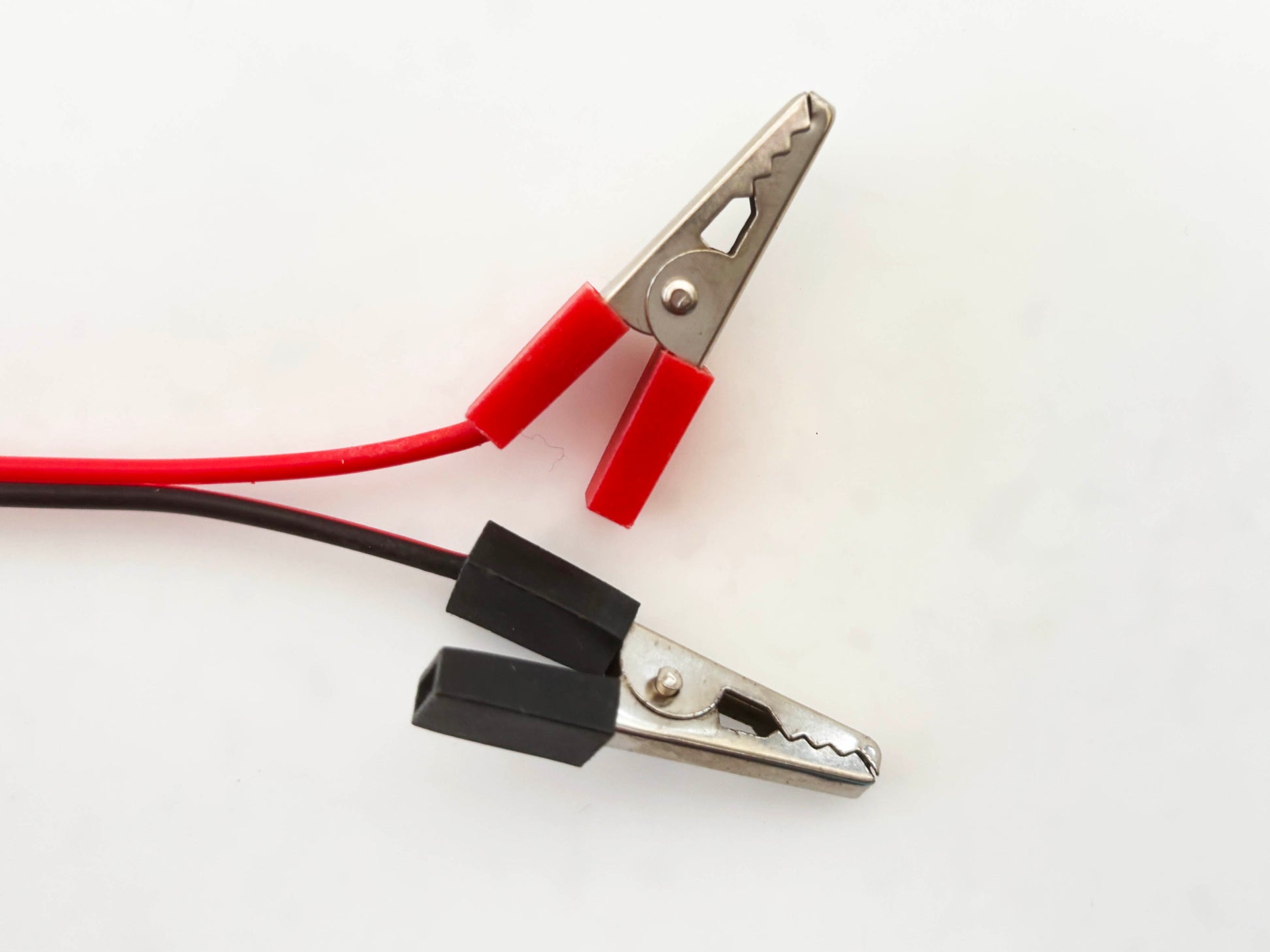Custom alligator clip with red and black leads on a white background