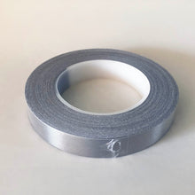 Load image into Gallery viewer, A roll of conductive tape in a plastic shrink wrap, The core of the roll is 7cm and the tape is 2cm wide
